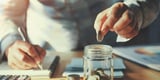 Business owner dropping coins in a jar, demonstrating how they're able to save money on fleet maintenance
