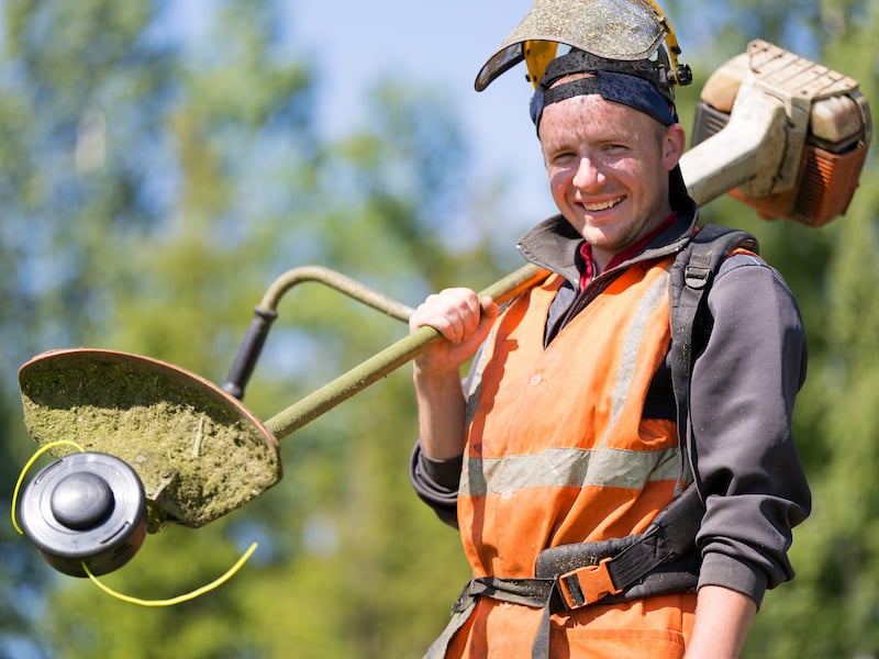 Smiling landscaper holding a landscaping asset