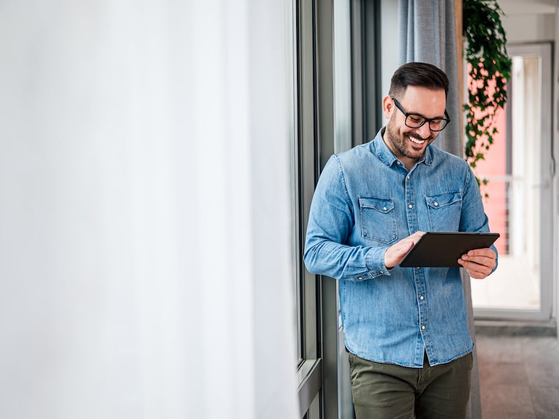 Smiling landscaping business owner tracking his fleet on his tablet